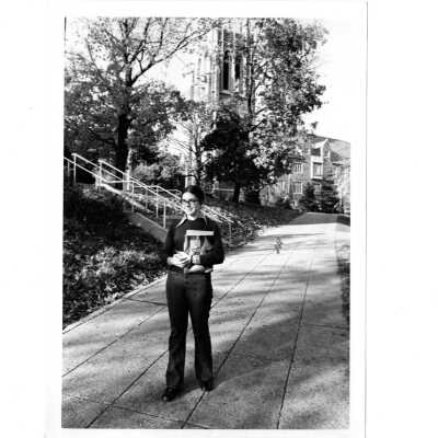 Student, Mary J. McDevitt, walking with Barbelin building in background.
