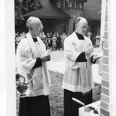 Laying and blessing of cornerstone of new Jesuit faculty residence with J. Joseph Bluett, S.J. and guests and Loyola in background