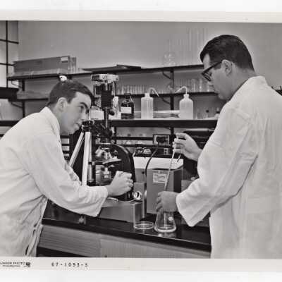 Two biology students conducting experiment in science laboratory, c. 1968.