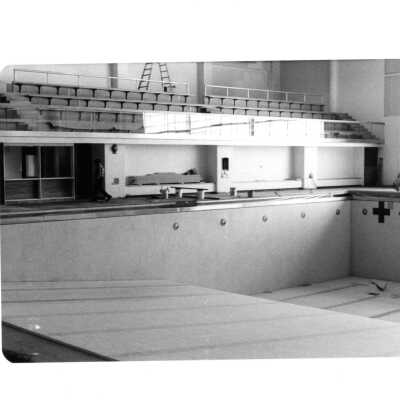 View of drained swimming pool and bleachers (under construction?) in Sports Complex.