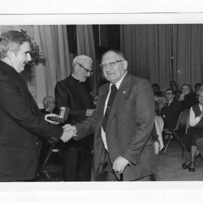 Louis S. Marks (Biology) receiving award from Nicholas S. Rashford, S.J., with Michael Smith, S.J., standing in background.