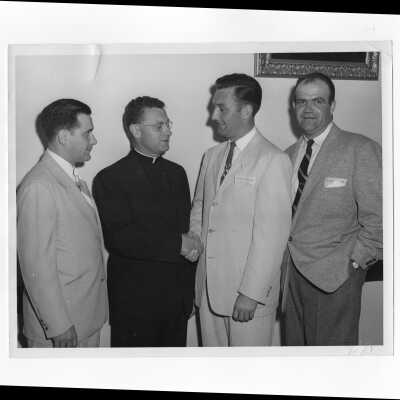 Edward G. Jacklin, S.J., welcoming alumni members including William Ariano and others, c. 1953.