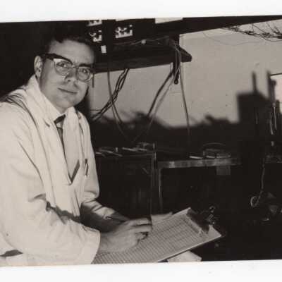Graduate chemistry student holding clipboard with data sheets in science laboratory, c. 1965.
