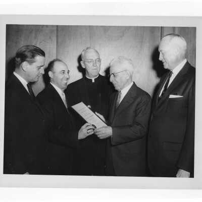 Dr. J. Parsons Schaeffer showing Shaffrey award certificate to J. Joseph Bluett, S.J. and others, 1959.