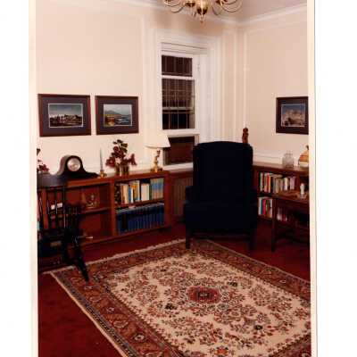 Interior of room in Regis Hall with wing chair and bookshelves.
