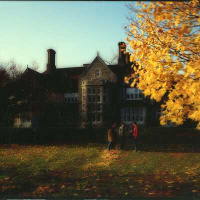 Exterior view of Saint Mary's Hall in autumn with students talking.