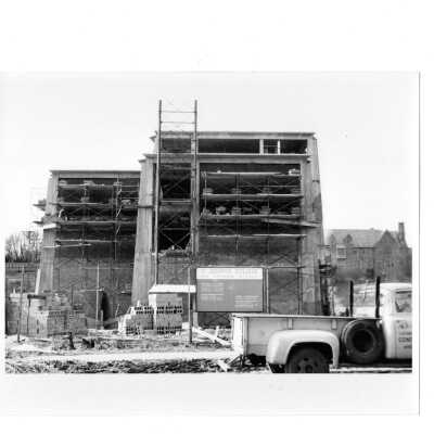 View of Bellarmine under construction with pick-up truck in foreground, Barbelin in background and construction sign,Carlos J. Alvare, architect, and John P. Donovan Co., General Contractor.
