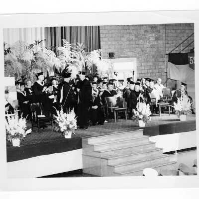 J. Joseph Bluett, S.J., conferring honorary degree to Robert D. Murphy (?) or Baron Silvercruys (?) during 1959 graduation/commencement ceremony.