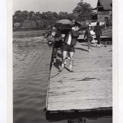 Men's crew/rowing team taking boat out of water at Boathouse Row on Schuylkill River.
