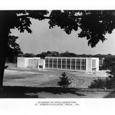 View of Finnesey Field and Villiger (later Post) Academy of Food Marketing with people running on track.