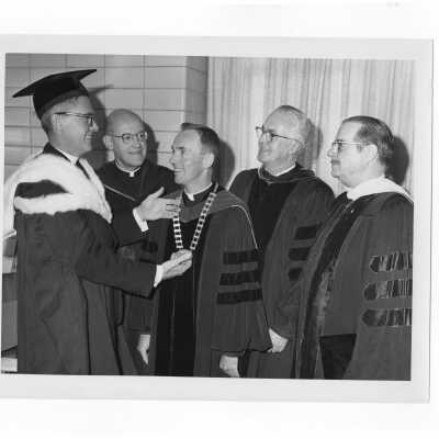 Inauguration of President Terrence Toland, S.J., November 14, 1968. Before ceremony, Toland shows Chain of Office to Jerome Coll, S.J. Paul Reinert, S.J., Mayor James H.J. Tate, and U.S. Senator Hugh Scott of Pennsylvania in a picture-taking session.