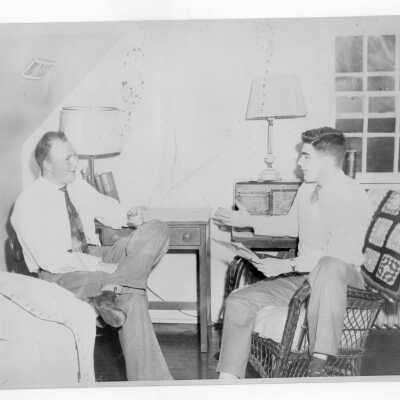 Two students from Barry Hall talking in dormitory room.