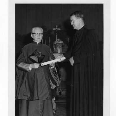 William F. Maloney, S.J., conferring honorary degree on Monsignor Francis J. Brennan during convocation, September 13, 1962.