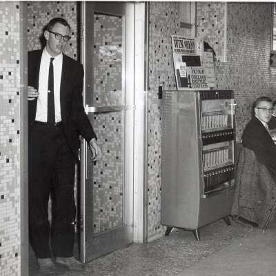 View of students in Campion cafeteria near cigarette machine.
