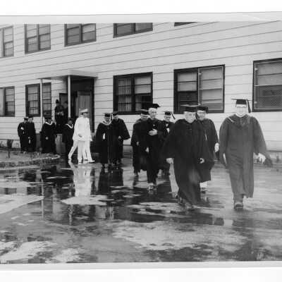 Faculty coming out of cardboard college processing to 1955 graduation/commencement ceremony.