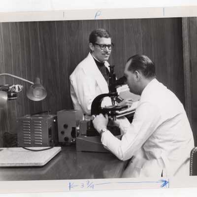 Biology professor and students using new microscope in science laboratory, March 1968.