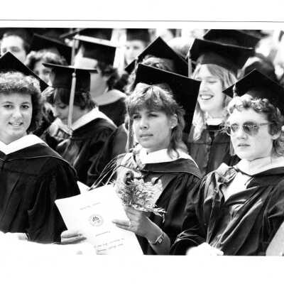 Views of small groups of graduating students during graduation/commencement, c. 1984.