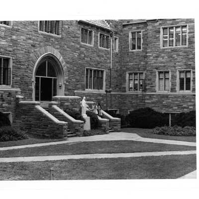 View of two female student walking up steps in Barbelin quadrangle near World War Two memorial.
