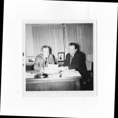 Frank A. Biglin and William J. Bates, Jr., annual giving directors of the alumni association, looking at fundraising figures, 1967.