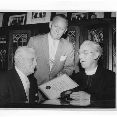 J. Joseph Bluett, S.J., and Dr. Tourish showing Shaffrey award certificate and medal to recipient, Dr. Bernard P. Widmann, April 27, 1958.