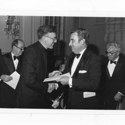 Donald I. MacLean, S.J., handing awards to Cornelius O'Brien, Daniel J. Henry, John J. Meehan, M.D., during alumni awards dinner, c. 1980.