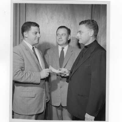 Edward G. Jacklin, S.J., receiving check from alumni officers, Carmen Casciato and Francis Lammer during Annual Giving drive, September 19, 1955.
