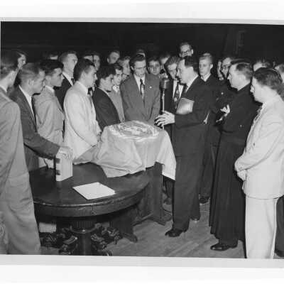 Saint Joseph's College students receiving a flag of the United Nations, c. 1949, with Matthew Sullivan, S.J. watching.