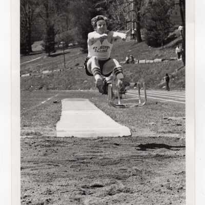 Men's track team member in long jump event on Finnesey Field.