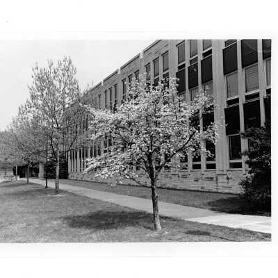 Exterior view of Villiger (later Post) Academy of Food Marketing with trees blooming.
