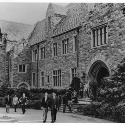 Students walking out of archway entrance of Barbelin building toward City Avenue.