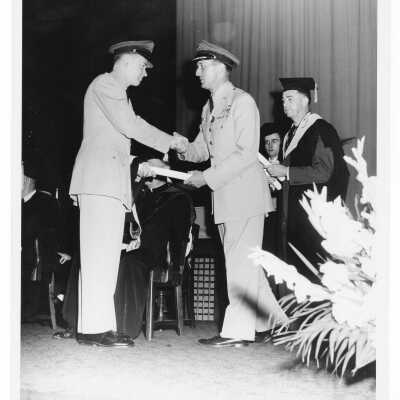 Graduating student, John Francis Miller, receiving Distinguished Air Force ROTC Graduate Designation from Colonel Raymond Gehrig during 1955 graduation/commencement.