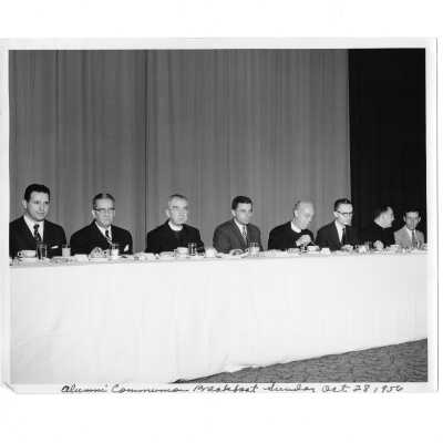 Head table at alumni communion breakfast, October 28, 1956, with Joe Pascucci, Paul O'Leary, J. Joseph Bluett, S.J., Joseph J. Hogan, S.J. and others.