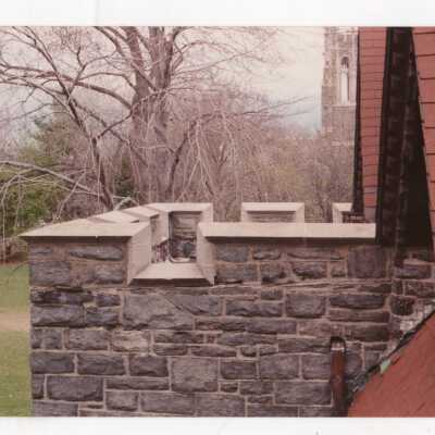 Exterior view of part of upper story of Wolfington Center (formerly Gest Estate, Neumann Hall) with Barbelin Tower in background.