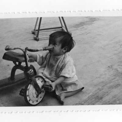Vietnamese child playing with tricycle, Vietnam Orphanage project.
