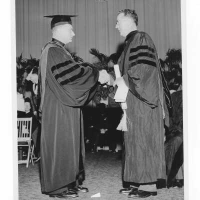 Edward G. Jacklin, S.J., congratulating honoree during 1956 graduation/commencement ceremony.