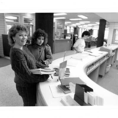 Three students at circulation desk in Drexel Library.