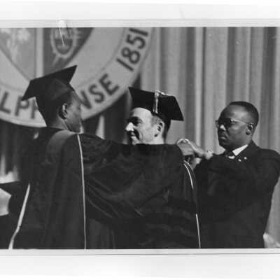 Francois Tombalbaye, President of Chad, presenting medal to honor Terrence Toland, S.J., during convocation, October 26, 1970.