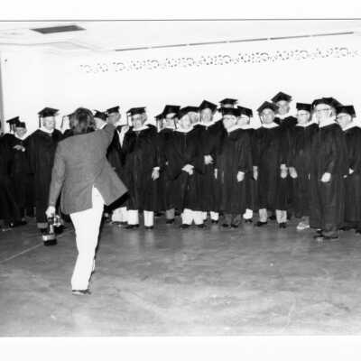 Group of alumni with photographer during 1990 graduation/commencement.