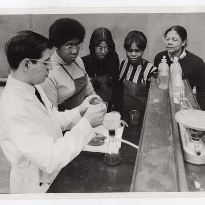 Tony Naddeo, graduate assistant, in science laboratory with several high school students participating in Chemistry Department's Science Motivation Program for high school students, May 1969.
