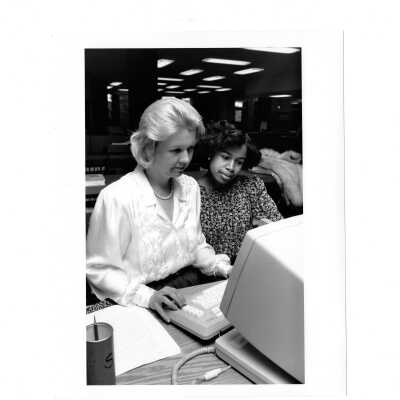 Ene Andrilli assisting student at computer terminal in Drexel Library.