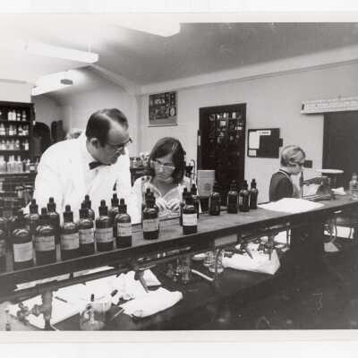 Chemistry professor working in science laboratory with several students, c. 1968.