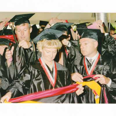 Masters degree students donning hoods during 1999 graduation/commencement.