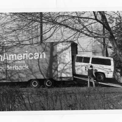 School van being unloaded by moving truck,