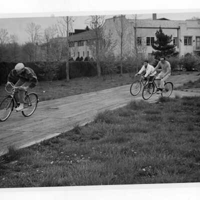 Three students in bicycle race during Junior Week activities.