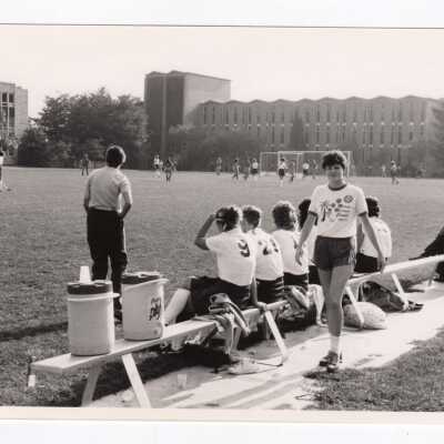 Women's field hockey match on Finnesey Field with Bellarmine in background.