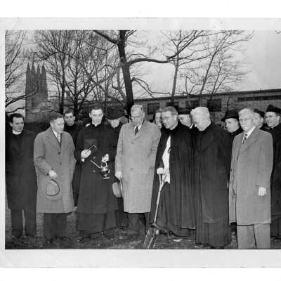 Groundbreaking for Field House (Sports Complex) with John Long,S.J., Howard Heim, S.J., James Buckley, S.J., Walter Hardren, S.J., Michael Maher, S.J., Thomas Stokes, S.J., John McShain, Fred Koehler, S.J., Joseph Hearn, S.J. with barracks in background.