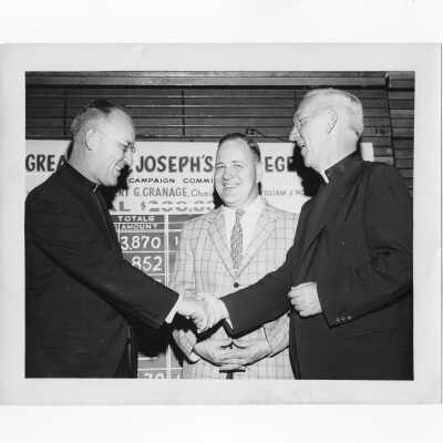 J. Joseph Bluett, S.J., congratulating William A. Ryan, S.J., and Robert Cranage during fundraising drive as part of capital gifts campaign, 1959.