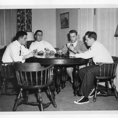 Four student residents of Barry Hall sitting at table playing cards.