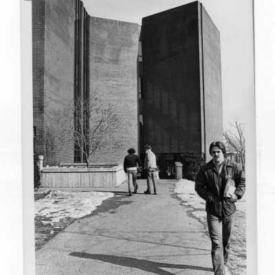 Students walking outside of science center in winter with snow on ground.