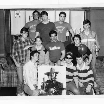 Residents of Hogan Hall with cigaretters and poster of Clint Eastwood.